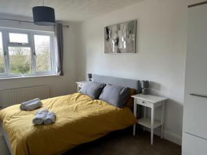 a bedroom with a bed with two towels on it at Partridge House • Sleeps 9 in Oakham