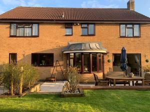 a house with a patio and a table in the yard at Partridge House • Sleeps 9 in Oakham