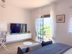 a living room with a couch and a tv at Las Vistas-Rincón acogedor con vistas al mar in Tabaiba