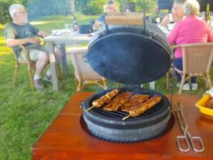 Una parrilla con un montón de salchichas. en Glamping Les Arbres, Luxe Safaritent met zwembad, en Cronat