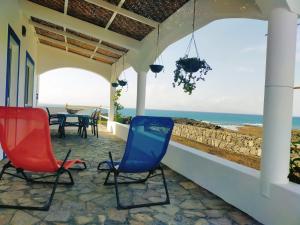a patio with chairs and a table and the ocean at Casa Branca in Porto Novo