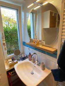 baño con lavabo, espejo y ventana en Accogliente appartamento con cucina arredata, en Ascona