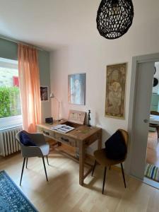 una camera con una scrivania, due sedie e una finestra di Accogliente appartamento con cucina arredata ad Ascona