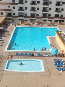 uma vista superior de uma grande piscina com pessoas nela em Аппартаметы Seguro De Sol Playa de la Arena em Puerto de Santiago