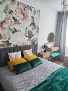 1 dormitorio con 1 cama con pared de flores en Centrum Miasta en Stargard Szczeciński