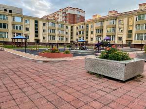 a brick courtyard with buildings and tables and flowers at Spacious 140m2, 2 bedrooms apartment in Ulaanbaatar