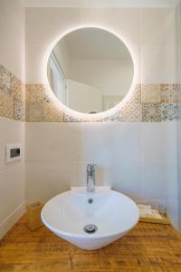 a bathroom with a white sink and a mirror at Minissale Farmhouse in Calatabiano