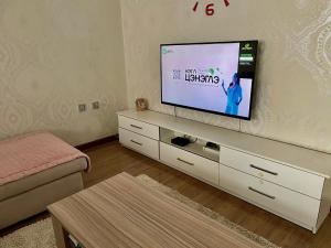 a living room with a flat screen tv on a cabinet at Spacious 140m2, 2 bedrooms apartment in Ulaanbaatar +11 photos
