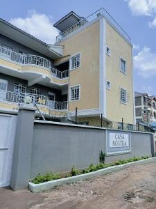 un grande edificio con un cartello di fronte di Casa nostra a Kakamega