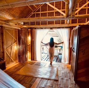 a woman standing in a room looking out of a window at Nature's Eye Resort in Guimaras