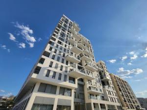 a tall white apartment building against a blue sky at Le Lucie - Bain de lumière au pied du métro in Bagneux