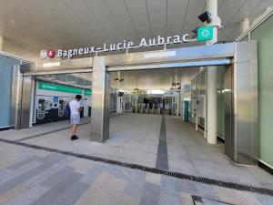 a man standing in the entrance to a shopping mall at Le Lucie - Bain de lumière au pied du métro in Bagneux +9 photos