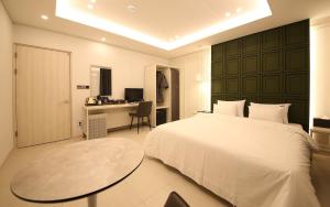 a bedroom with a bed and a desk and a table at Brown Dot Hotel Sinan in Gwangju +84 photos