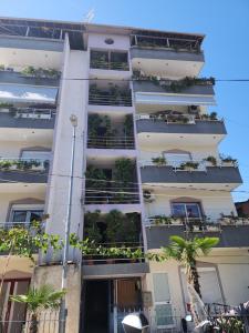 un edificio de apartamentos blanco con plantas en los balcones en Tirana Class House en Tirana