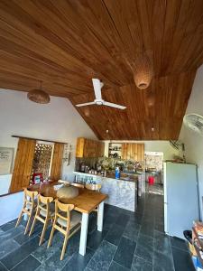 a kitchen with a wooden ceiling and a table and chairs at Vom Vom Garden House in Da Nang