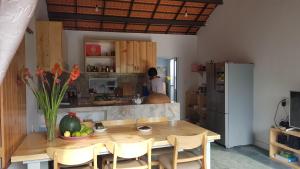 eine Küche mit einem Holztisch und einem Kühlschrank in der Unterkunft Vom Vom Garden House in Đà Nẵng