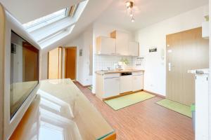 a kitchen with white cabinets and wooden floors at Maria Gabriele Karlstrasse 6b Ferienwohnung 12 in Kolpinsee