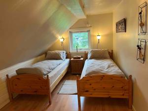 a bedroom with two beds and a window at Nakkentunet - familievennlig hus på gårdstun. in Ørskog