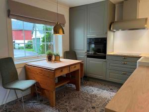 eine Küche mit einem Holztisch und einer Arbeitsplatte in der Unterkunft Nakkentunet - familievennlig hus på gårdstun. in Ørskog