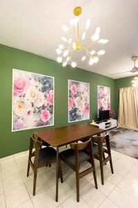 a dining room with a table and paintings on the wall at LeCOMFY GUESTHOUSE HOMESTAY TAMBUN IPOH with UNIFI, NETFLIX,AIRCOND in Ipoh