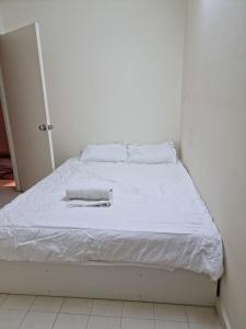 a white bed with a white blanket on it at LeCOMFY GUESTHOUSE HOMESTAY TAMBUN IPOH with UNIFI, NETFLIX,AIRCOND in Ipoh