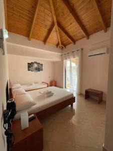 um quarto com uma cama grande e um tecto de madeira em Belvedere Hotel & Suites em Himare