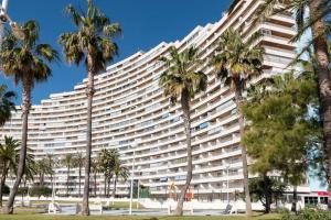 ein großes Gebäude mit Palmen davor in der Unterkunft apartamento al mar cullera florazar in Cullera