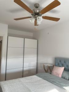 a ceiling fan in a bedroom with a bed at Stan na Dan "Cherry" in Novi Sad