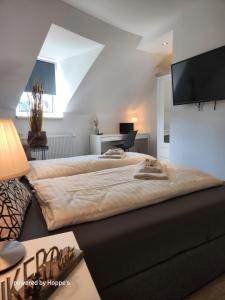 1 dormitorio con 1 cama grande y TV de pantalla plana en Hotel Hoppe, en Witten