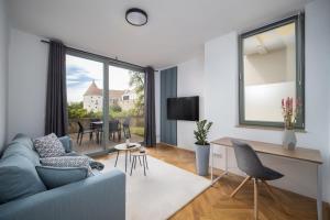 a living room with a blue couch and a table at CoView - Bautzen - Design Apartment in der Altstadt mit fantastischem Ausblick in Bautzen