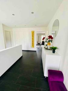 Duży pokój z białymi ścianami i fioletową ławką w obiekcie The Paradise - am Hallwilersee w mieście Meisterschwanden