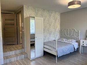 - une chambre avec un lit et un miroir dans l'établissement Apartament COMFORT Centrum, à Krotoszyn