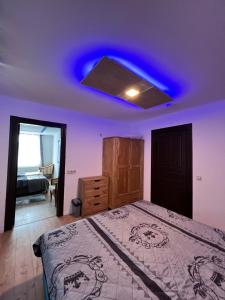 a bedroom with a blue light on the ceiling at Gera Apartment in Gera