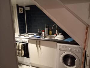 een keuken met een wastafel en een wasmachine bij Cosy 2 Bedroom Flat Newport in Newport