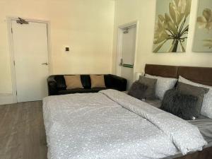 a bedroom with a large bed and a couch at Cosy 1 Bedroom Flat-Newport (F2) in Newport