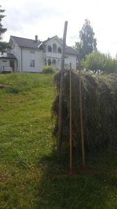 a large pile of hay in front of a house at Søberget in Stange
