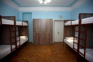 a room with three bunk beds and a blue wall at Hostello in Baku