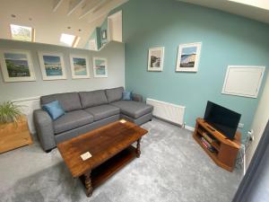 a living room with a couch and a tv at The Annexe, Tregoose House in Newquay