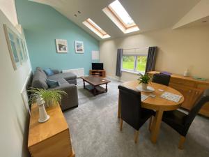 uma sala de estar com uma mesa e um sofá em The Annexe, Tregoose House em Newquay