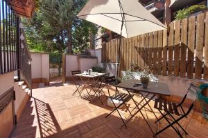 a patio with two tables and an umbrella at Vatican Flat Cozy with Private Court in Rome