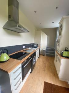 a kitchen with white cabinets and a stove top oven at The Annexe, Tregoose House in Newquay