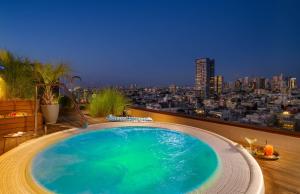 a large swimming pool on the roof of a building at Carlton Tel Aviv Hotel – Luxury on the Beach in Tel Aviv