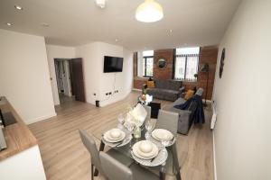 ein Wohnzimmer mit einem Tisch, Stühlen und einem Sofa in der Unterkunft Bv Luxury Apartment Conditioning House in Bradford