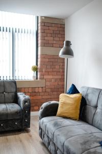 ein Wohnzimmer mit einem Sofa und einem Stuhl in der Unterkunft Bv Luxury Apartment Conditioning House in Bradford