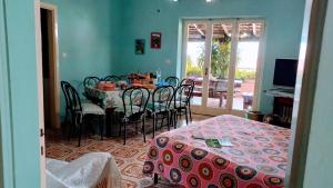 a dining room with a table and chairs and a television at The Secret Garden Maratea - Casa di Sery in Maratea