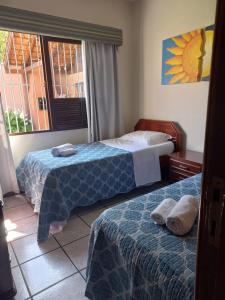 a bedroom with two beds and a window at Casa Itoupava Norte in Blumenau