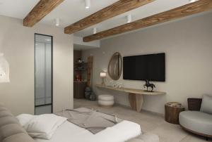 a living room with a television on a wall at Alexandra Golden Boutique Hotel-Adults Only in Chrysi Ammoudia