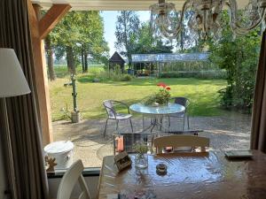 een terras met een tafel en stoelen bij B&B Het mooie uitzicht in Reuver