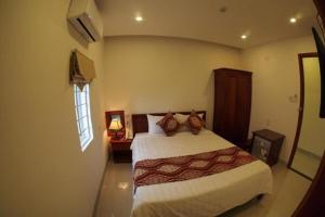a bedroom with a large bed and a window at Hùng Thư Motel in Da Nang