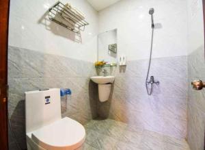 a bathroom with a white toilet and a shower at Hùng Thư Motel in Da Nang